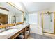 Bathroom with double vanity, granite counters, and a glass-enclosed shower at 1932 Sandhurst Dr, Castle Rock, CO 80104