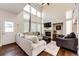 Bright living room with soaring ceilings, large windows, and a cozy fireplace at 1932 Sandhurst Dr, Castle Rock, CO 80104