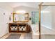 Bright main bathroom featuring double sinks, vanity with storage and a separate tub and shower at 1932 Sandhurst Dr, Castle Rock, CO 80104