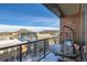 Balcony with a table and mountain views with a wrought iron railing, brick exterior, and snow on the ground at 20 Wilcox St # 518, Castle Rock, CO 80104