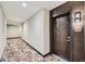Well-lit condo hallway with patterned carpeting, neutral walls, and dark wood door with unit number 518 at 20 Wilcox St # 518, Castle Rock, CO 80104