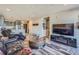 Bright living room with wood floors, a large TV, and a view of the open kitchen and front door at 20 Wilcox St # 518, Castle Rock, CO 80104