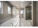 Bright bathroom offers a soaking tub, walk-in shower, and dual vanities at 15194 W Washburn Ave, Lakewood, CO 80228