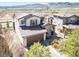 A beautiful home featuring stone accents, a well-manicured lawn, and mountain views at 15194 W Washburn Ave, Lakewood, CO 80228