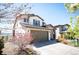 Two-story home featuring stone accents, a well-maintained lawn, a two car garage and mature landscaping at 15194 W Washburn Ave, Lakewood, CO 80228