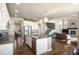 Open-concept kitchen boasts stainless appliances, an island with seating, and hardwood floors at 15194 W Washburn Ave, Lakewood, CO 80228