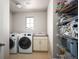 Convenient laundry room with washer, dryer, sink, and storage shelving at 15194 W Washburn Ave, Lakewood, CO 80228