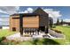 Contemporary home with a stone patio, outdoor fireplace, and large windows at 11168 Wild Chase Pl, Franktown, CO 80116