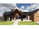 A contemporary home with a covered entryway, large windows, and wood and metal siding at 11168 Wild Chase Pl, Franktown, CO 80116
