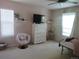 Bedroom featuring a cozy pink chair, a TV on a chest of drawers, and natural light at 569 Alton Way # E, Denver, CO 80230