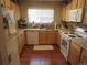 Functional kitchen with oak cabinets, white appliances, and a window for natural light at 569 Alton Way # E, Denver, CO 80230