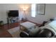 Cozy living room features wood floors, a tufted ottoman, and a comfortable sofa at 569 Alton Way # E, Denver, CO 80230