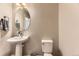 Clean half-bathroom with a pedestal sink and toilet, showcasing a minimalist design and neutral color palette at 16057 E 47Th Pl, Denver, CO 80239
