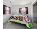 Bedroom featuring large quilted bed, two windows, and ample closet space at 1995 Xenia St, Denver, CO 80220