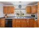 Traditional kitchen featuring wood cabinets, double sinks, and a window above the sink offering a view to the yard at 1995 Xenia St, Denver, CO 80220