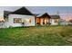 Backyard view of a modern farmhouse with a covered porch and a well-manicured lawn at 451 W 152Nd Ave, Broomfield, CO 80023