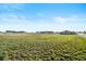 Expansive grassy lot with a view of a modern farmhouse and barn under a clear blue sky at 451 W 152Nd Ave, Broomfield, CO 80023