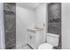 Well-lit bathroom with modern vanity and marbled tile shower and dark marbled accent wall tiles at 524 Rider Ridge Dr, Longmont, CO 80504