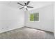 Neutral bedroom with carpeted floor, ceiling fan, and view from window at 524 Rider Ridge Dr, Longmont, CO 80504