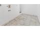Bright, white tiled laundry room area with utility hookups awaiting appliances at 524 Rider Ridge Dr, Longmont, CO 80504