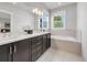 Bathroom features a double sink vanity with dark cabinets, modern lighting and luxurious bathtub at 1140 S Sherman St, Denver, CO 80210