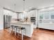 Open kitchen layout with stainless steel appliances, island seating, and hardwood floors at 1140 S Sherman St, Denver, CO 80210