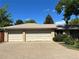 Spacious three-car garage with an expansive concrete driveway and brick exterior at 1602 S Lamar St, Lakewood, CO 80232