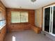 Bright sun room with wood paneling, brick accent wall, and sliding glass doors at 1602 S Lamar St, Lakewood, CO 80232