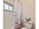 Bathroom featuring a floral shower curtain and a clean, white toilet at 5721 Everett St, Arvada, CO 80002
