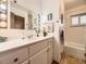 Well-lit bathroom with vanity, large mirror, and combination tub and shower at 5721 Everett St, Arvada, CO 80002