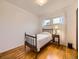 Cozy bedroom with hardwood flooring, a twin bed, and a bedside table at 5721 Everett St, Arvada, CO 80002