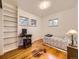 Bedroom with built-in shelves, hardwood floors, a desk, and a twin bed at 5721 Everett St, Arvada, CO 80002