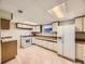 Basement kitchen with white appliances, light wood cabinets, and vinyl flooring at 5721 Everett St, Arvada, CO 80002