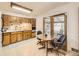 Bright kitchen featuring wooden cabinets, tiled backsplash, and eat-in dining area at 5721 Everett St, Arvada, CO 80002