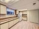 Basement kitchen with lots of countertop space, cabinets, a large window, and wood floor at 5721 Everett St, Arvada, CO 80002