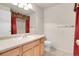 Well-lit bathroom featuring a vanity with sink, mirror, and toilet, accented with a decorative curtain at 6295 Clayton Cir, Frederick, CO 80530