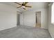 Bedroom with carpet, ceiling fan, ensuite bathroom, and large window at 6295 Clayton Cir, Frederick, CO 80530