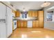 Bright kitchen with wood cabinets, white appliances, and hardwood floors at 6295 Clayton Cir, Frederick, CO 80530