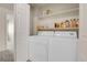 Convenient laundry area with a modern washer and dryer, complemented by shelving for storage at 6295 Clayton Cir, Frederick, CO 80530