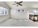 Bright living room featuring plush carpet, fireplace, ceiling fan, and natural light at 6295 Clayton Cir, Frederick, CO 80530