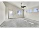 Well-lit living room featuring plush carpet, large windows, and a ceiling fan at 6295 Clayton Cir, Frederick, CO 80530