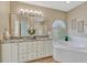 A luxurious bathroom with double vanities, a soaking tub, and a window with shutter blinds at 12344 Turquoise Terrace St, Castle Pines, CO 80108