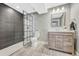 Modern bathroom with gray tile walls, a walk-in shower, and sleek vanity with wood accents at 12344 Turquoise Terrace St, Castle Pines, CO 80108