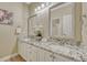 Bathroom with dual vanities, granite countertops, and contemporary mirrors and lighting at 12344 Turquoise Terrace St, Castle Pines, CO 80108