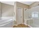 Modern bathroom features a glass enclosed shower, soaking tub, and wood look floors at 12344 Turquoise Terrace St, Castle Pines, CO 80108