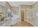 Bright bathroom with a soaking tub, glass shower, wood-look tile flooring and granite countertops at 12344 Turquoise Terrace St, Castle Pines, CO 80108