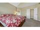 Spacious bedroom featuring neutral walls, plush carpeting, and a comfortable bed with a red floral comforter at 12344 Turquoise Terrace St, Castle Pines, CO 80108