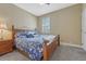 Comfortable bedroom featuring neutral walls, plush carpeting, and a wood bed with blue floral bedding at 12344 Turquoise Terrace St, Castle Pines, CO 80108