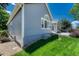 Side view of the home showing the light blue siding, manicured lawn, and decorative rock landscaping at 12344 Turquoise Terrace St, Castle Pines, CO 80108