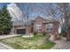 Beautifully landscaped brick home featuring a green lawn, mature tree, and classic architectural details at 12344 Turquoise Terrace St, Castle Pines, CO 80108